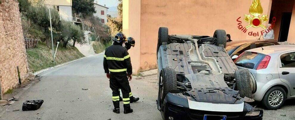 Auto si ribalta e si schianta contro le vetture in sosta, intervengono i vigili del fuoco